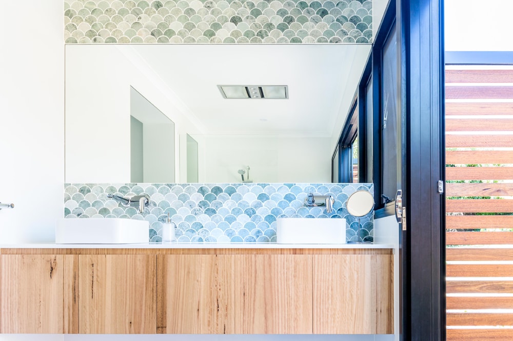 indoor-outdoor bathroom with blue and green fishscale tiles in Canberra