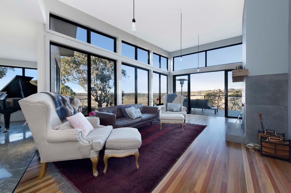 Living room with large windows overlooking Australian country landscape