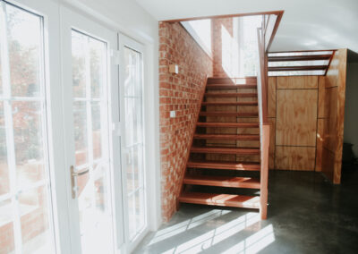 Timber staircase and new walls in renovated room - connects storage basement to garden and kitchen
