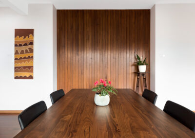 Dining table of mid century extension with new timber feature wall in background
