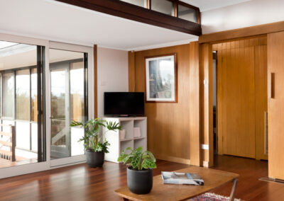 Midcentury Heritage House in Canberra: Neville Gruzman/s Kennard House. Lounge room space with highlight windows and access to bedrooms via original timber sliding door.