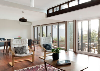 Open plan living room with lots of windows looking out over a subuarban Canberra garden.