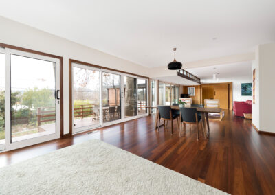 Open plan living room with lots of windows looking out over a subuarban Canberra garden.