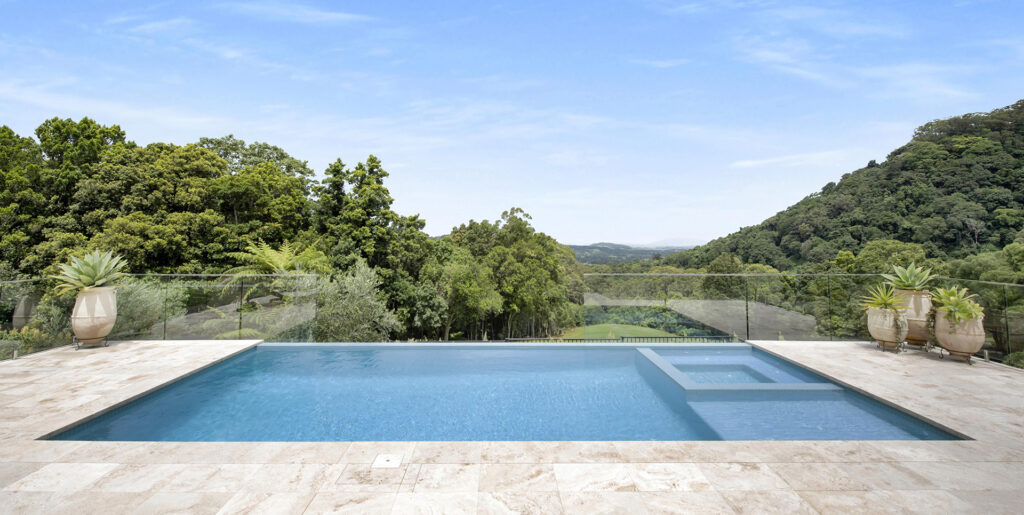 Eyecatching image of a pool with waterfall edge that looks out over the Kiama Hinterland.