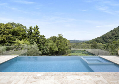 Eyecatching image of a pool with waterfall edge that looks out over the Kiama Hinterland.