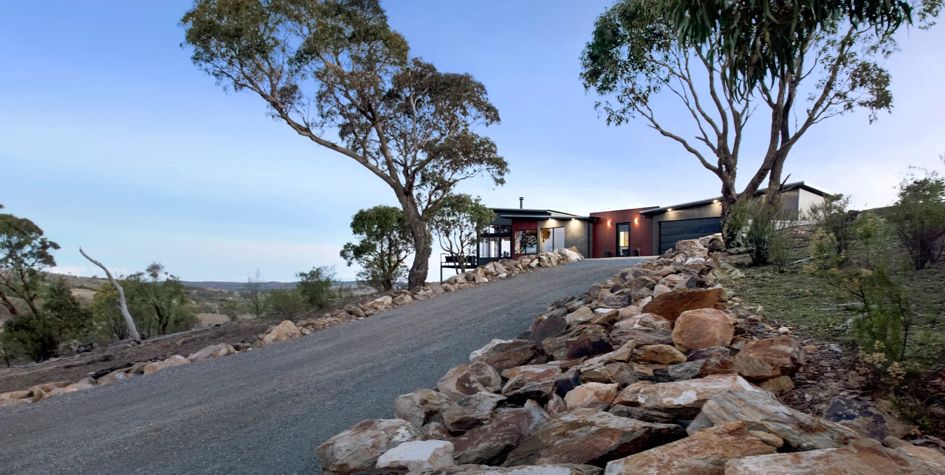 Driveway of Wamboin Country House showing the homestead flanked by two eucalypts.